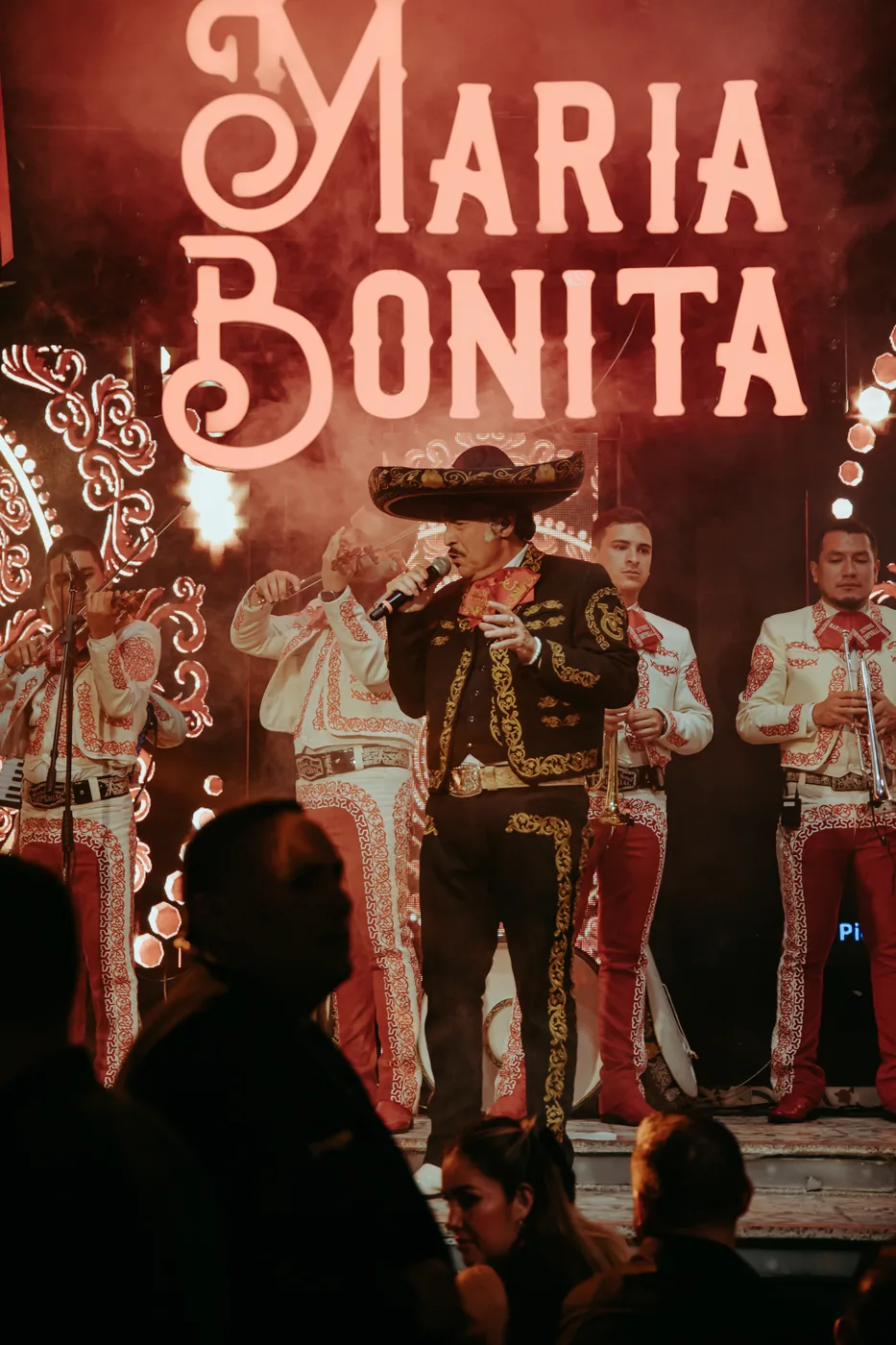 Danny Solís cantando en tarima con mariachi