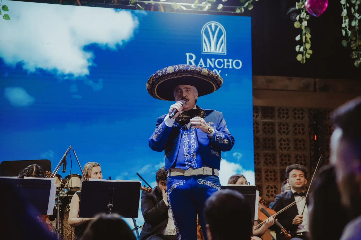 Danny Solís cantando en escenario con orquesta